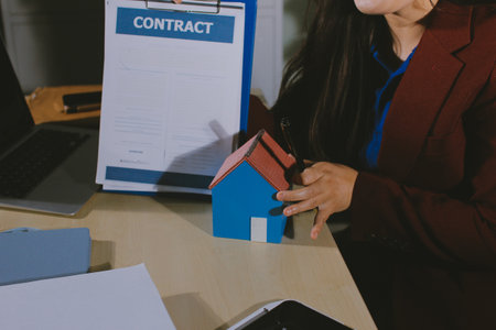 Customer signing a real estate contract in real estate agency.