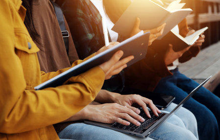 Happy students walking together on university campus, chatting and laughing outdoors after classesの写真素材