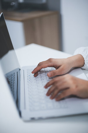 Middle aged female doctor working on laptop in doctor's room