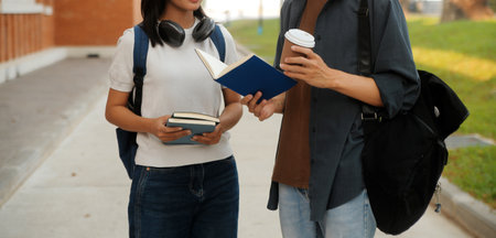 Happy students walking together on university campus, chatting and laughing outdoors after classesの写真素材