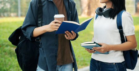Happy students walking together on university campus, chatting and laughing outdoors after classes
