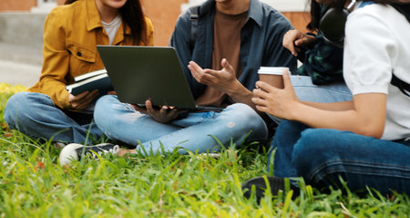 Happy students walking together on university campus, chatting and laughing outdoors after classesの写真素材