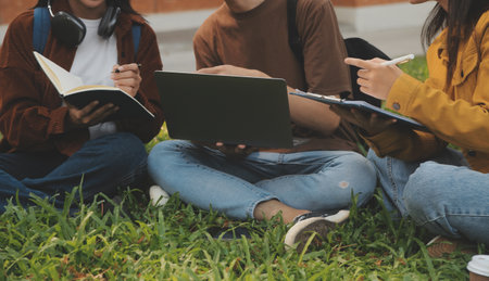 Happy students walking together on university campus, chatting and laughing outdoors after classes