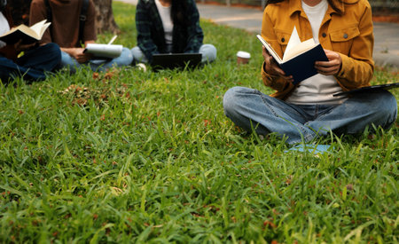 Happy students walking together on university campus, chatting and laughing outdoors after classesの写真素材