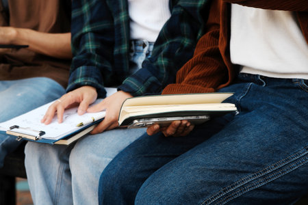 Happy students walking together on university campus, chatting and laughing outdoors after classesの写真素材