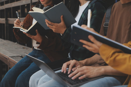 Happy students walking together on university campus, chatting and laughing outdoors after classesの写真素材