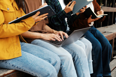 Happy students walking together on university campus, chatting and laughing outdoors after classesの写真素材