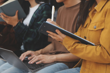 Happy students walking together on university campus, chatting and laughing outdoors after classesの写真素材