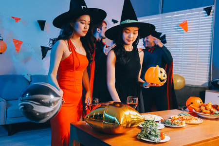 Joyful Halloween party with coworkers in costumes, celebrating with drinks and laughter, fostering teamwork and festive spiritの写真素材