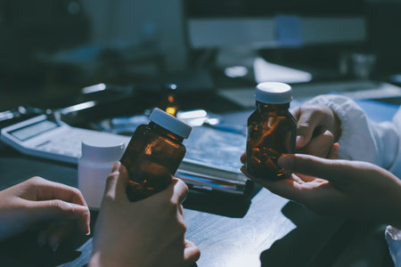 Female doctor holding a medicine bottle is checking the quality of medicine for any side effects the patient or not and recording patient information at the hospital. medical and health care conceptの写真素材