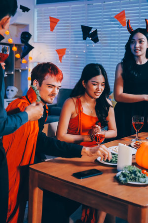 Joyful office Halloween party with coworkers in costumes, celebrating with drinks and laughter, fostering teamwork and festive spiritの写真素材