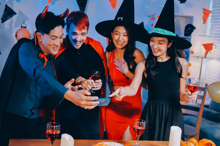 Joyful Halloween party with coworkers in costumes, celebrating with drinks and laughter, fostering teamwork and festive spiritの写真素材