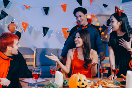 Joyful office Halloween party with coworkers in costumes, celebrating with drinks and laughter, fostering teamwork and festive spiritの写真素材