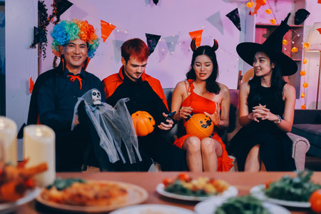 Joyful office Halloween party with coworkers in costumes, celebrating with drinks and laughter, fostering teamwork and festive spiritの写真素材