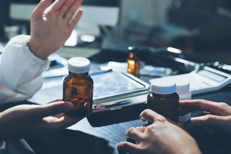 Female doctor holding a medicine bottle is checking the quality of medicine and recording patient information at the hospital. Medical and health care conceptの写真素材