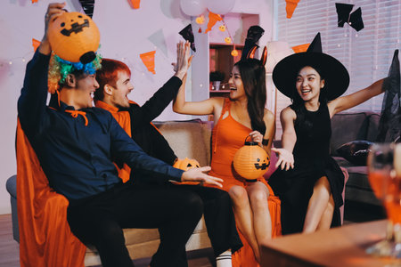 Joyful Halloween party with coworkers in costumes, celebrating with drinks and laughter, fostering teamwork and festive spiritの写真素材