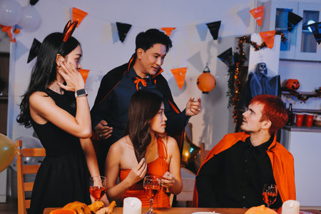 Joyful office Halloween party with coworkers in costumes, celebrating with drinks and laughter, fostering teamwork and festive spiritの写真素材