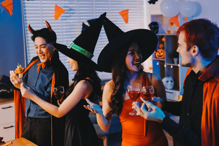 Joyful Halloween party with coworkers in costumes, celebrating with drinks and laughter, fostering teamwork and festive spiritの写真素材