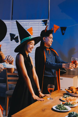 Joyful Halloween party with coworkers in costumes, celebrating with drinks and laughter, fostering teamwork and festive spiritの写真素材