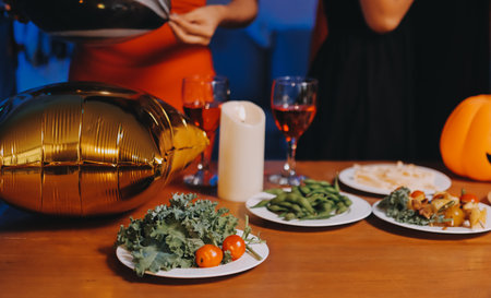 Joyful office Halloween party with coworkers in costumes, celebrating with drinks and laughter, fostering teamwork and festive spiritの写真素材