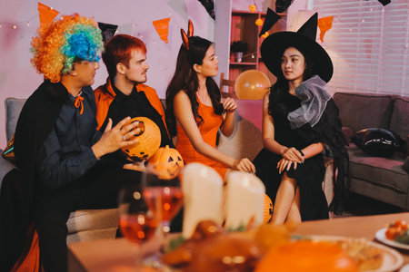 Joyful Halloween party with coworkers in costumes, celebrating with drinks and laughter, fostering teamwork and festive spiritの写真素材