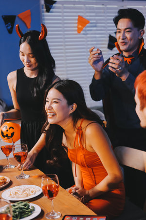 Joyful office Halloween party with coworkers in costumes, celebrating with drinks and laughter, fostering teamwork and festive spiritの写真素材
