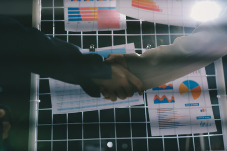 Business people shaking hands in office. Two business partners shaking hands after signing a contract in office.の写真素材