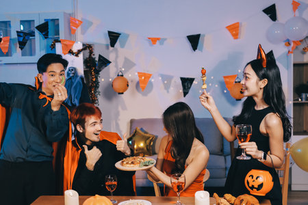 Joyful Halloween party with coworkers in costumes, celebrating with drinks and laughter, fostering teamwork and festive spiritの写真素材