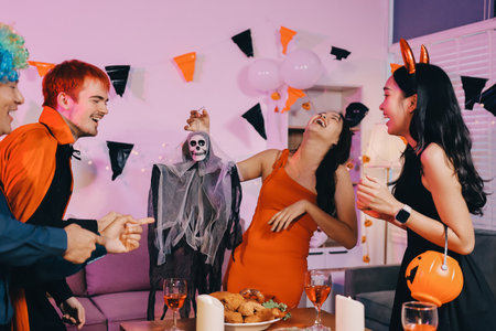 Joyful office Halloween party with coworkers in costumes, celebrating with drinks and laughter, fostering teamwork and festive spiritの写真素材