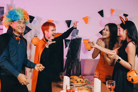 Joyful Halloween party with coworkers in costumes, celebrating with drinks and laughter, fostering teamwork and festive spiritの写真素材