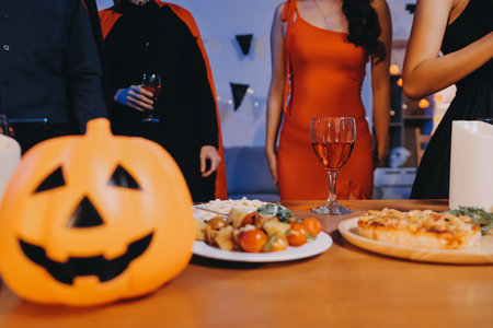 Joyful office Halloween party with coworkers in costumes, celebrating with drinks and laughter, fostering teamwork and festive spiritの写真素材