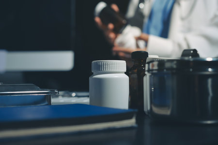 Two doctors and a female nurse meet at a table in the hospital, collaborating on medical tasks using laptops and computersの写真素材