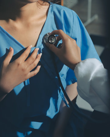 healthy concept; Doctor checking patient's heart with stethoscope at a hospitalの写真素材