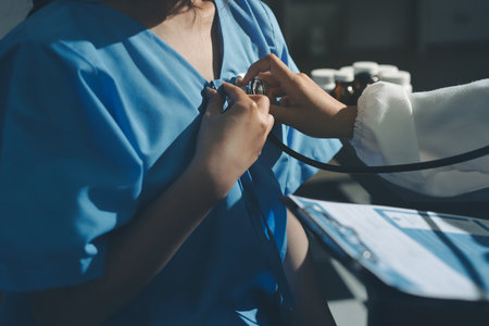 healthy concept; Doctor checking patient's heart with stethoscope at a hospitalの写真素材