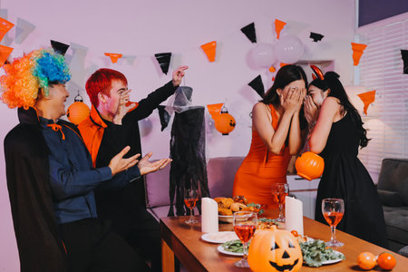 Joyful Halloween party with coworkers in costumes, celebrating with drinks and laughter, fostering teamwork and festive spiritの写真素材