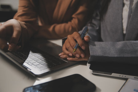 Close up Business woman using calculator and laptop for do math finance on wooden desk, tax, accounting, statistics and analytical research conceptの写真素材