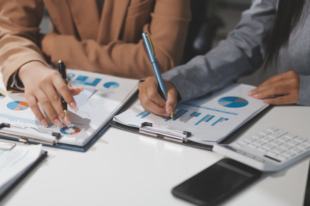Close up Business woman using calculator and laptop for do math finance on wooden desk, tax, accounting, statistics and analytical research conceptの写真素材