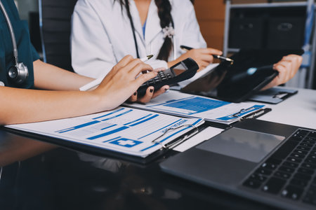 Group of doctors attending seminar in hospital lecture hall with senior physician giving medical presentation and professional training session on healthcare practicesの写真素材
