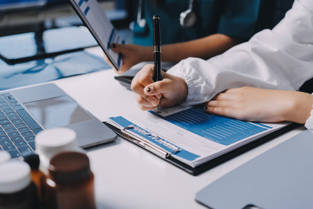 Group of doctors attending seminar in hospital lecture hall with senior physician giving medical presentation and professional training session on healthcare practicesの写真素材
