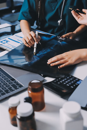 Group of doctors attending seminar in hospital lecture hall with senior physician giving medical presentation and professional training session on healthcare practicesの写真素材