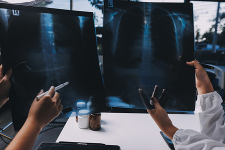 Group of doctors attending seminar in hospital lecture hall with senior physician giving medical presentation and professional training session on healthcare practicesの写真素材