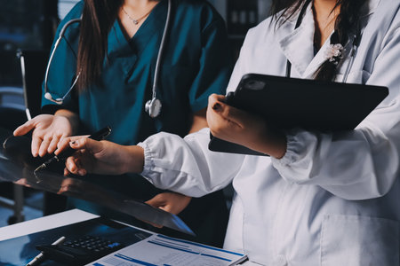 Group of doctors attending seminar in hospital lecture hall with senior physician giving medical presentation and professional training session on healthcare practicesの写真素材