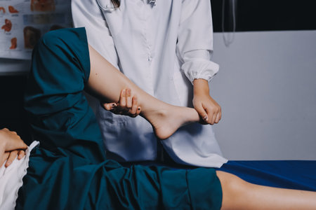 Rehabilitation therapy Professional male physiotherapists working in rehabilitation centers while treating male patients with leg and muscle pain.の写真素材