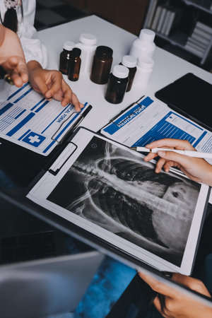 Group of doctors attending seminar in hospital lecture hall with senior physician giving medical presentation and professional training session on healthcare practicesの写真素材