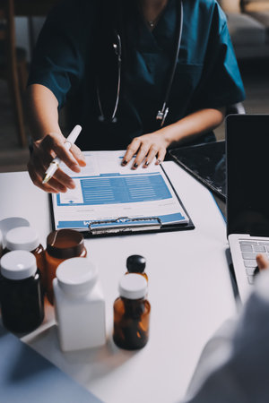 Group of doctors attending seminar in hospital lecture hall with senior physician giving medical presentation and professional training session on healthcare practicesの写真素材