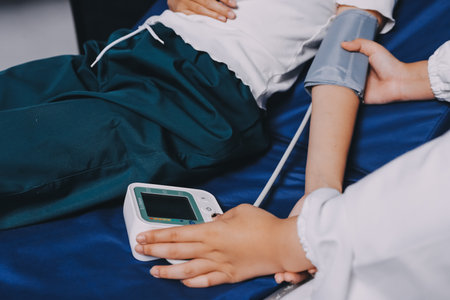 Nurse measuring blood pressure of elderly woman at table, closeup. Assisting senior generationの写真素材