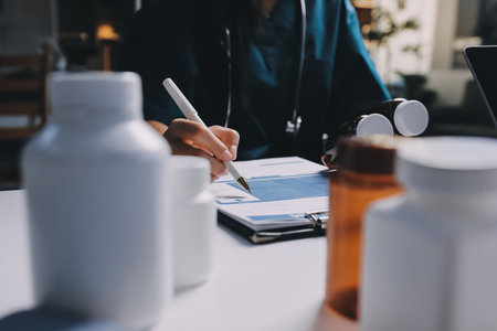 Group of doctors attending seminar in hospital lecture hall with senior physician giving medical presentation and professional training session on healthcare practicesの写真素材