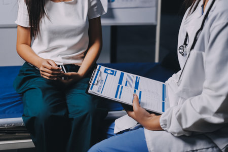 Compassionate Female Doctor Examining Senior Patient in Hospital Bed, Showing Empathy and Careの写真素材
