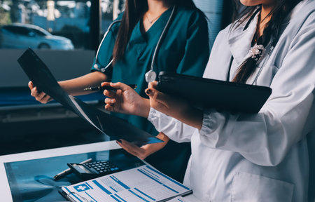 Group of doctors attending seminar in hospital lecture hall with senior physician giving medical presentation and professional training session on healthcare practicesの写真素材