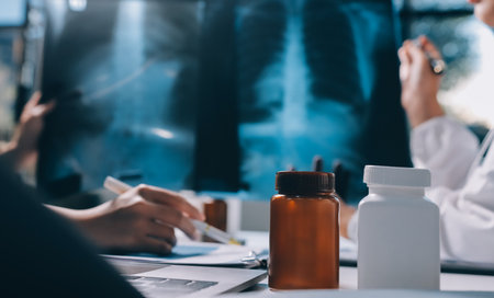 Group of doctors attending seminar in hospital lecture hall with senior physician giving medical presentation and professional training session on healthcare practicesの写真素材